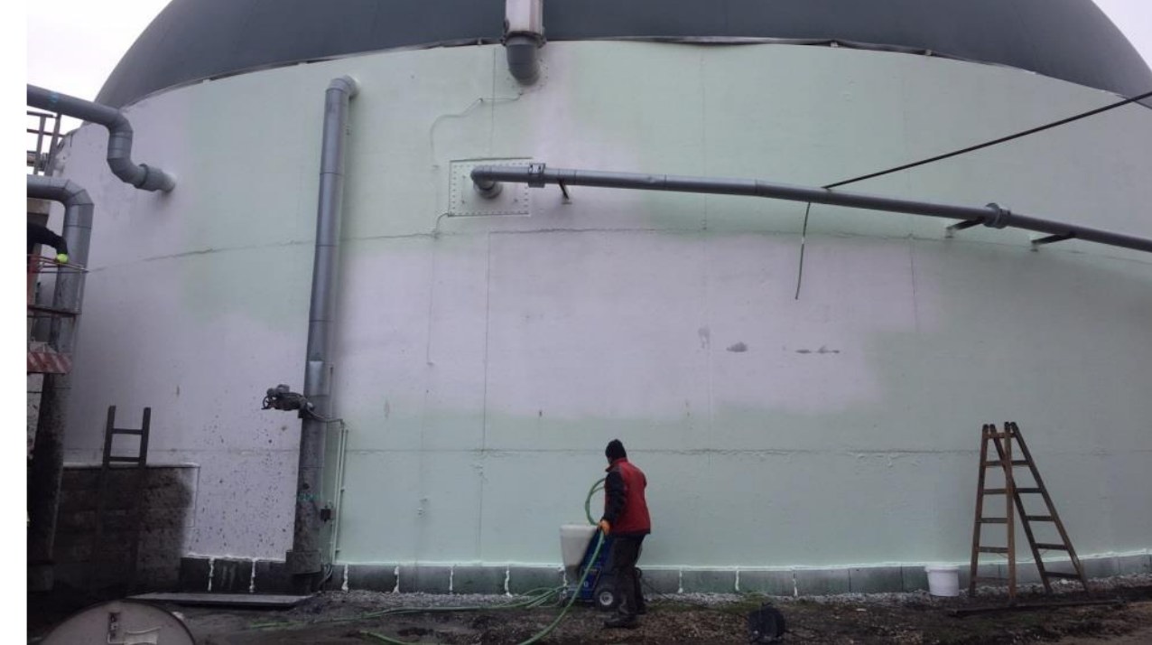 Arbeiter appliziert PSC-Beschichtung an der Wand eines Biogas-Fermenter-Tanks